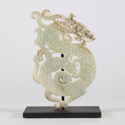 Pendentif en jade vert à décor de deux Chilong, Chine, dans le style des Royaumes combattants Pendentif ajouré en jade vert translucide, finement sculpté d’un décor en léger relief figurant deux dragons chilong entrelacés aux corps sinueux, ponctués de motifs spiralés en bosse. Le traitement du relief, la composition symétrique et la stylisation des têtes évoquent les productions du style archaïsa