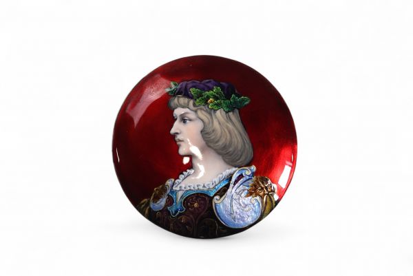 Médaillon en cuivre émaillé, Limoges, XIXᵉ siècle Médaillon circulaire en cuivre émaillé polychrome représentant un portrait en buste de Claude de France, de profil à gauche, vêtue d’un riche costume Renaissance rehaussé d’émaux translucides bleu, pourpre et or sur fond rouge rubis. Le traitement délicat du visage, la finesse des détails du costume et la vivacité de la palette évoquent les product