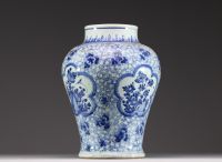 China - A white-blue porcelain baluster vase decorated with flowers, mugwort leaf mark within a double circle, Kangxi.