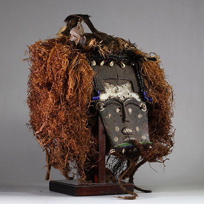 Rare masque Lele ( Bashilele) d’une grande complexité matérielle et stylistique, RD Congo. Bois, raphia, terre, perles, plumes et peau d’animal.  La patine est ancienne et riche, résultant d’une longue utilisation tribale, comme en témoigne également les réparations indigènes sur le visage. La forme du visage est classique. Les ornements sont multiples et extrêmement symboliques. Début XXème ou an