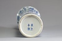 Chine - Vase cylindre en porcelaine blanc bleu à décor de personnages et pagodes dans un paysage arboré et montagneux.