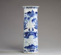 Chine - Vase cylindre en porcelaine blanc bleu à décor de personnages et pagodes dans un paysage arboré et montagneux.