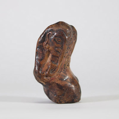 Fragment sculpté en pierre représentant une figure anthropomorphe à trompe, probablement Ganesh. Inde ou Himalaya, XIXe siècle. La composition s’intègre harmonieusement aux irrégularités naturelles du galet, caractéristique d’un travail rituel populaire, probablement issu d’un contexte religieux localisé dans le nord de l’Inde ou les régions himalayennes. L’objet pourrait avoir servi de talisman p