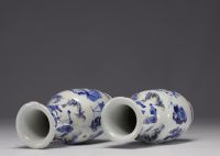 Chine - Paire de vases en porcelaine bleu blanc à décor de personnages, marque de Kangxi,  XIXe siècle.