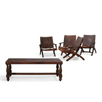 Angel Pazmiño .Ensemble de mobilier comprenant quatre fauteuils, une table basse et un pouf Bois massif et cuir patiné à décor repoussé, Équateur, vers 1960.