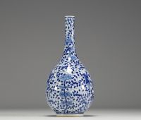 China - White-blue porcelain vase decorated with a figure holding a large covered vase, double circle mark under the piece.