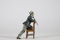 Bronze de Vienne, XIXᵉ siècle Petite figure en bronze polychrome représentant un homme assis à l’envers sur une chaise, vêtu d’un costume bourgeois avec chapeau haut-de-forme, gants blancs et canne. Il s’agit d’un exemple typique des bronzes de Vienne du XIXᵉ siècle, appréciés pour leurs sujets pittoresques, souvent inspirés du théâtre, des scènes de genre ou de la vie citadine.