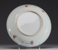 China - A polychrome porcelain plate decorated with trees and flowers, 18th century.