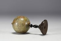 J.L. & Cie pour Lebègue à Paris - Globe terrestre miniature en papier ciré sur piètement en bois tourné.