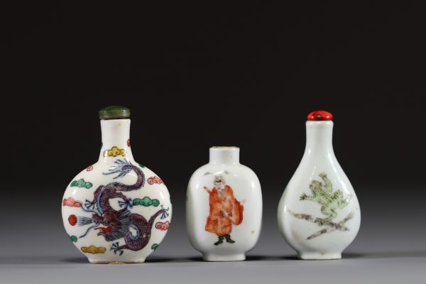 Chine - Ensemble de trois tabatières en porcelaine polychrome famille rose à décor de dignitaire, de fleurs, de grenouille et de dragon.