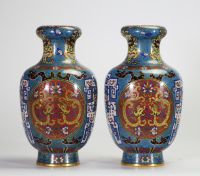 Rare paire de vases en cloisonné à décor de dragons affrontés dans des médaillons et motifs archaïsants, Chine, dynastie Qing, XIXe siècle Paire de vases balustres en laiton finement ornés d’émaux cloisonnés polychromes sur fond bleu turquoise, décorés de médaillons circulaires figurant des dragons affrontés sur fond rouge orné de nuées, encadrés de motifs archaïsants en registres, frises de ruyi,