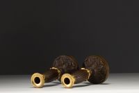 A pair of small gilt bronze candlesticks with a brown patina, from the Restoration period.