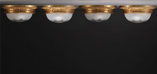 Ensemble de quatre plafonniers en bronze doré et vasques en cristal taillé.