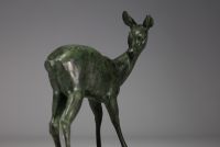 Grande sculpture d'une biche en régule à patine verte sur socle en marbre rose et noir, non signée.