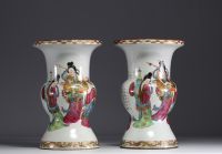 China - A pair of famille rose porcelain vases decorated with dignitaries, courtesans and poems, 19th century.