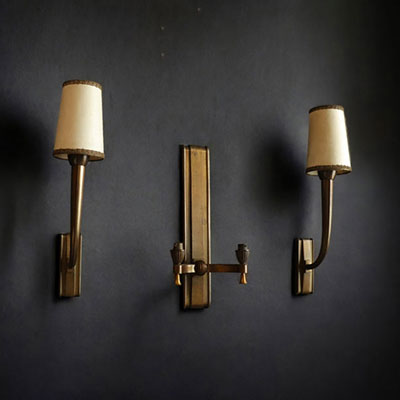 Jean PASCAUD (1903-1996) Set consisting of a double sconce and a pair of single sconces in patinated gilt bronze.