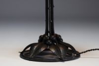 DAUM Nancy - Art Nouveau lamp in forged metal with plant decoration, globe in translucent coloured glass, signed.