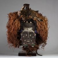 Rare masque Lele ( Bashilele) d’une grande complexité matérielle et stylistique, RD Congo. Bois, raphia, terre, perles, plumes et peau d’animal.  La patine est ancienne et riche, résultant d’une longue utilisation tribale, comme en témoigne également les réparations indigènes sur le visage. La forme du visage est classique. Les ornements sont multiples et extrêmement symboliques. Début XXème ou an