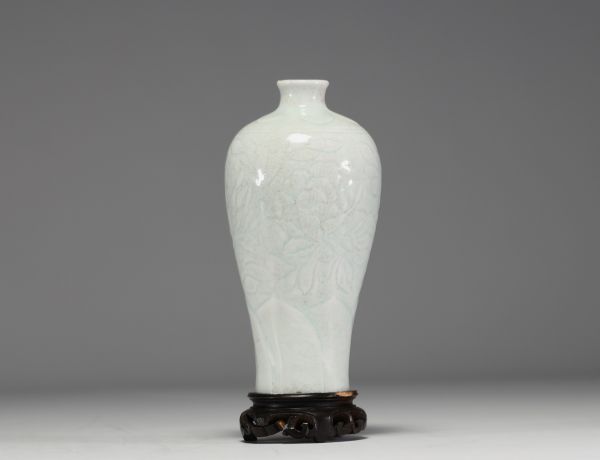 China - An 18th century celadon porcelain vase decorated with flowers in relief.