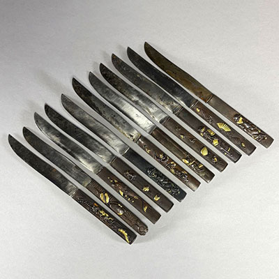 Japon - Suite de douze couteaux à fruits, manches kozuka en bronze et autres alliages métalliques, XIXème.