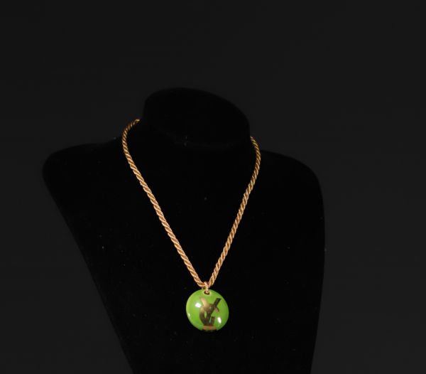 Yves SAINT LAURENT - Pendentif en porcelaine de couleur verte et or, monogrammé YSL.