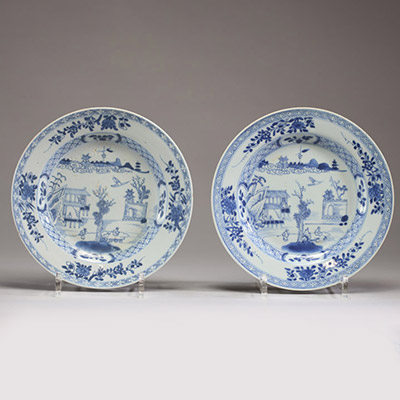 Chine - Paire d'assiettes en porcelaine blanc bleu à décors de personnages et de temple, époque Kangxi.