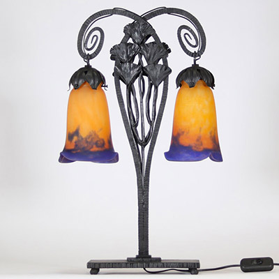 Muller Frères, Lunéville, vers 1905 Lampe à deux lumières en fer forgé martelé à décor de ginkgo biloba et verreries multicouches signées.  Superbe lampe Art Nouveau en fer forgé patiné noir, montée sur une base rectangulaire, s’élevant en double col de cygne à volutes stylisées. Le fût est orné de feuilles et hampes florales de ginkgo biloba, motif emblématique du symbolisme végétal de la Belle É