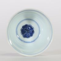 Chine, petit bol en porcelaine bleu et blanc à décor extérieur de caractères bouddhiques stylisés alternant avec des lotus, l’intérieur orné d’une fleur centrale, marque apocryphe à six caractères de 