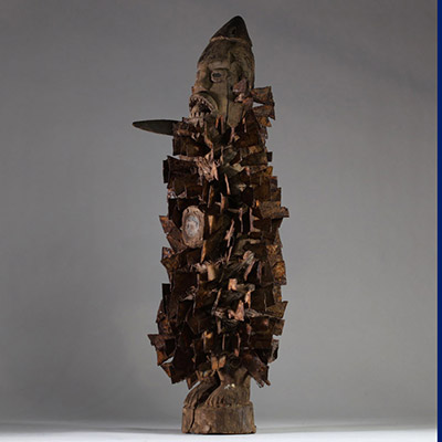 Ancienne figure de pouvoir Nkisi Nkondi Kongo ( Yombe), région du Mayombe forestier, entre Boma (RDC), Ngoyo et Cabinda, RD Congo. La figure, taillée dans un bois ancien à patine profonde, se tient debout, dans une posture frontale autoritaire. Dotée de tous les attributs d'efficacité magique (bilongo en verre, yeux en verre, couteau, coiffe conique, clous de fer, bouche ouverte), il incarne la pu