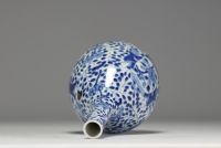 China - White-blue porcelain vase decorated with a figure holding a large covered vase, double circle mark under the piece.