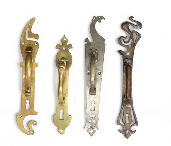 Ensemble de quatre poignées de porte à poucier en bronze patiné - Belgique - Vers 1900.