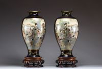 Japon - Grande paire de vases en porcelaine à décor en cartouche de jeunes femmes et d'enfants, reposant sur des socles en bois d'époque Meiji, XIXe siècle.
