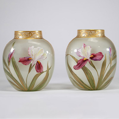 Paire de vases en verre translucide finement émaillés à décor de fleurs d’iris dans des tons pourpres, verts et blancs, soulignés de rehauts d’or. Frise en relief doré au col. Travail français de la p