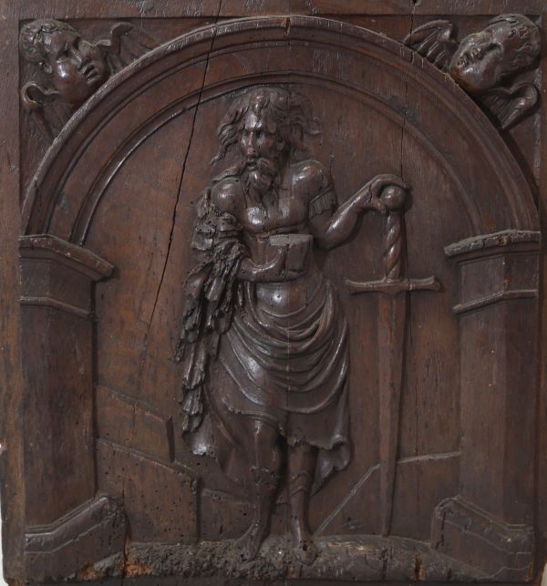 Panneau sculpté en chêne figurant saint Paul apôtre et martyr debout sous une arche architecturée. Deux têtes d’anges en fort relief ornent les écoinçons supérieurs travail flamand, probablement fin XVIe - début XVIIe siècle