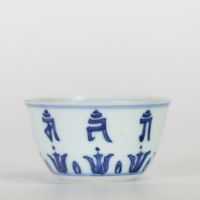Chine, petit bol en porcelaine bleu et blanc à décor extérieur de caractères bouddhiques stylisés alternant avec des lotus, l’intérieur orné d’une fleur centrale, marque apocryphe à six caractères de 