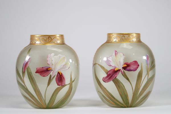Paire de vases en verre translucide finement émaillés à décor de fleurs d’iris dans des tons pourpres, verts et blancs, soulignés de rehauts d’or. Frise en relief doré au col. Travail français de la p