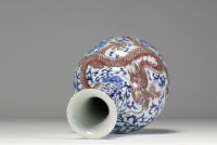 China - A white-blue porcelain vase decorated with a dragon and an iron-red phoenix, mark under the piece, 18th century.