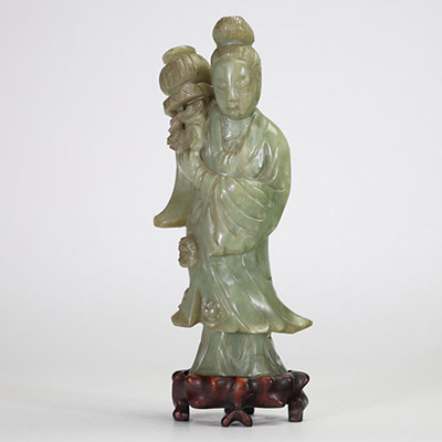 Statuette en jade céladon représentant une élégante, Chine, dynastie Qing, XIXe siècle Sculptée dans une pierre jade céladon nuancée, la figure incarne une jeune femme debout tenant un vase fleuri à l