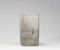 Daum Nancy, vase losangique à décor émaillé en grisaille, scène hollandaise au moulin Raffiné vase en verre opalescent de forme losangique, à décor peint en grisaille représentant une scène hollandaise avec moulin, maisons et silhouettes de voiliers. La finesse du trait et le rendu atmosphérique confèrent à cette pièce un charme poétique propre à certaines productions de la maison Daum. Signature