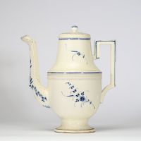 Boch Luxembourg, vers 1790–1810 Cafetière en porcelaine fine à décor bleu sous couverte Modèle de forme Directoire, à panse moulurée, couvercle bombé à prise bouton en toupie, anse à angles vifs et bec en tête zoomorphe stylisée. Décor de rinceaux végétaux, frises dentelées et filets bleu cobalt. Rare exemple du style néo-classique sobre et équilibré développé à la manufacture de Septfontaines.