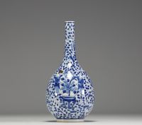 China - White-blue porcelain vase decorated with a figure holding a large covered vase, double circle mark under the piece.