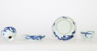 Chine, dynastie Qing – Ensemble de quatre bols et soucoupes en porcelaine bleu et blanc à décor de dragons parmi les nuées