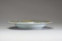 Chine – Assiette en porcelaine de la Compagnie des Indes à décor peint en grisaille et or d’une scène de famille, XVIIIe siècle. Charmante assiette à bord chantourné en porcelaine, décorée en grisaill