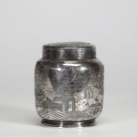 Chine, vers 1900 Pot à thé en argent massif gravé, à décor de paysages animés  Pot à thé de forme balustre en argent massif finement gravé d’un paysage traditionnel chinois, animé de scènes de village, pavillons, montagnes, oiseaux en vol et figures humaines. Le couvercle est orné d’un large chrysanthème stylisé dans un médaillon circulaire. La base est marquée au revers, vraisemblablement d’un or