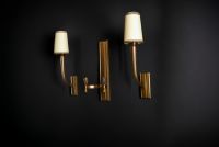 Jean PASCAUD (1903-1996)  Ensemble composé d'une applique double et d'une paire d'appliques simples en bronze doré patiné.